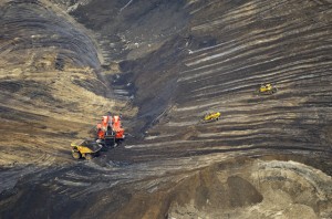 Bulldozers and trucks at the bottom of the oil sands