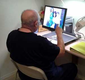 Elderly man uses a video magnifier