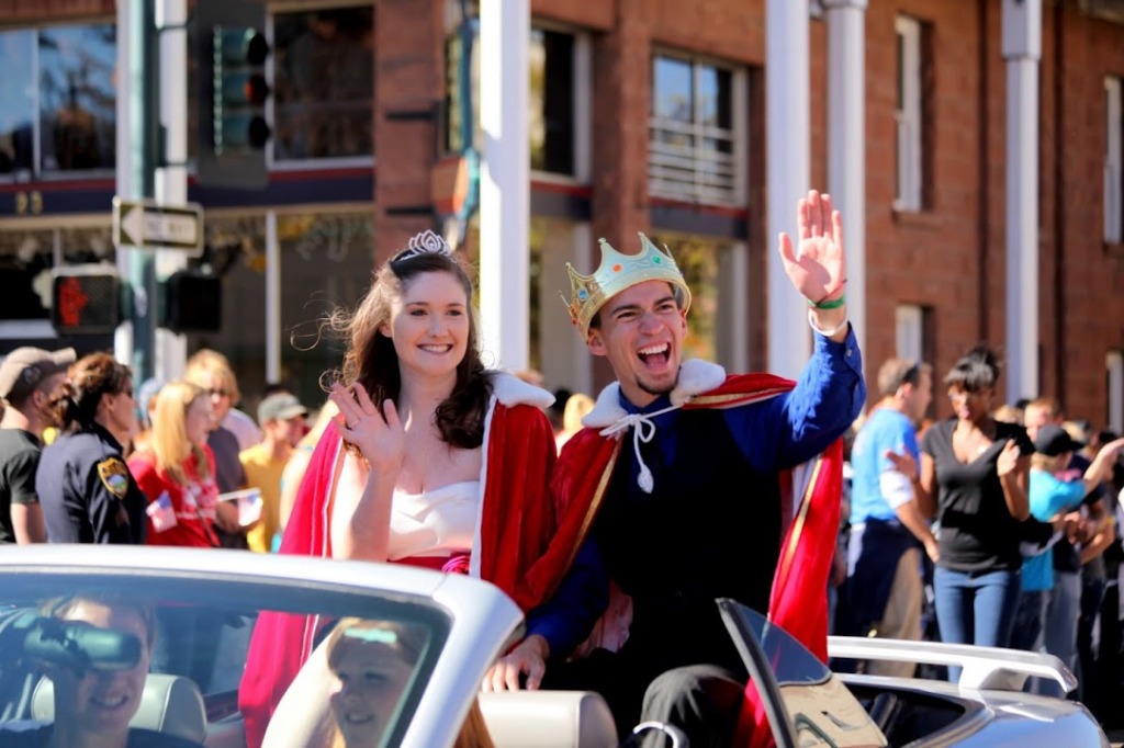 Homecoming king and queen wave in the parade
