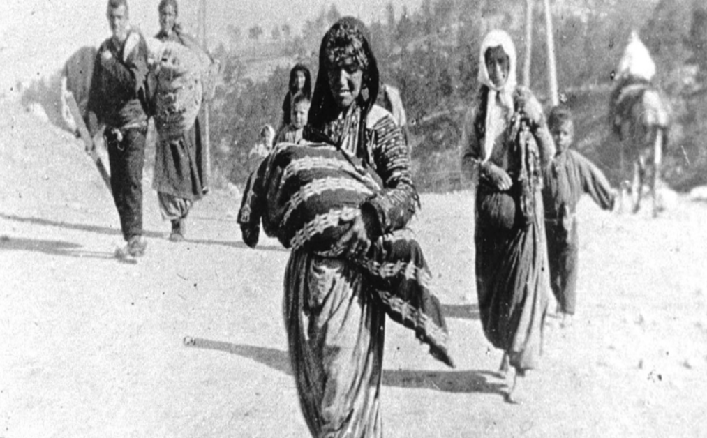A woman walks amongst others, holding a baby