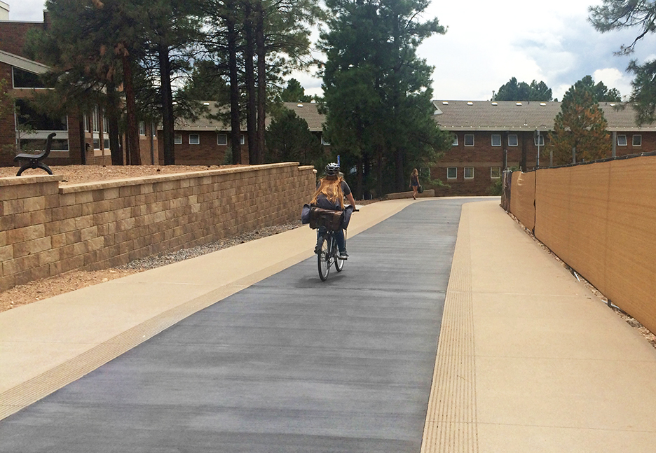 New pedway design featuring a dark gray concrete bike lane running between two lighter gray pedestrian pathways.