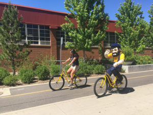 Girl and Louie riding yellow bikes on pedway