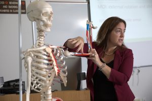 Athletic training professor teaching with skeleton