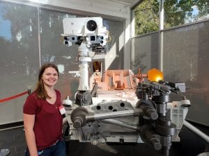 Lamm standing with replica model of Curiosity rover
