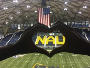 Hands make heart shape around NAU letters