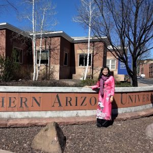 Visiting Fulbright scholar in front of NAU sign