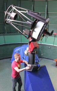 Colin Chandler works on telescope
