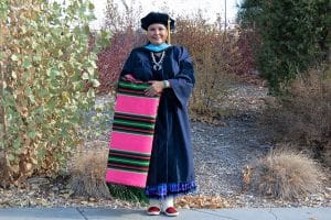 Esther Cadman in her commencement regalia and traditional Navajo dress