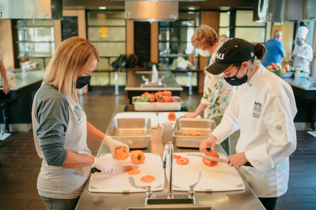 Volunteers chop food in the NAU test kitchen