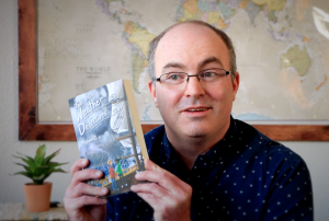 Michael Erb holds up his book, "The Weather Detectives"