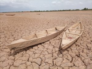 Canoes sit on dry lakebed.