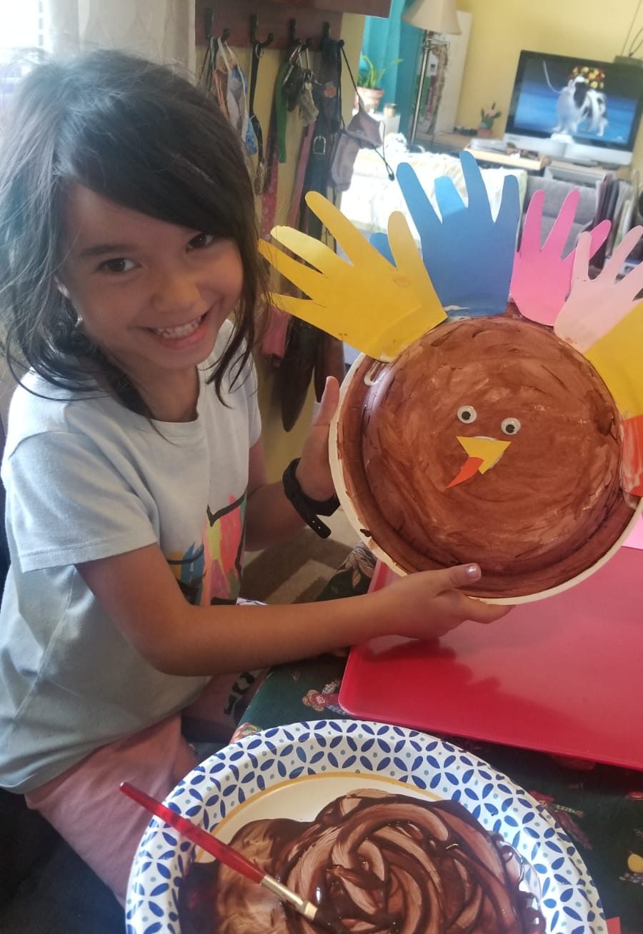 Girl holds up turkey craft