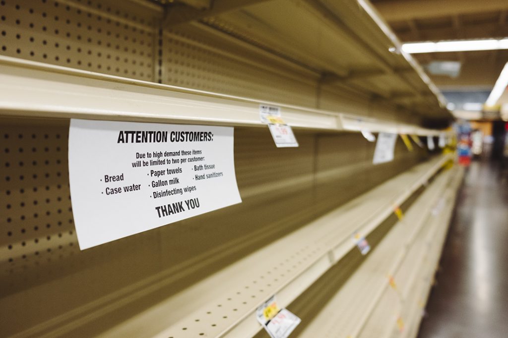 Empty shelves with a sign about shortages