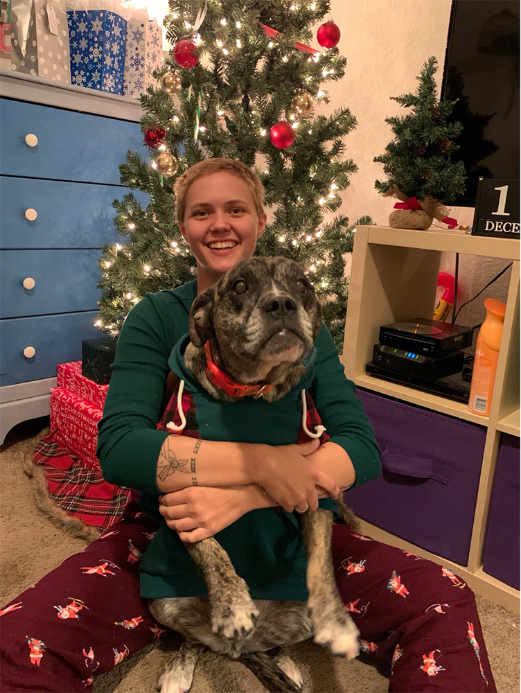 Laurel Malm and her dog in front of a Christmas tree