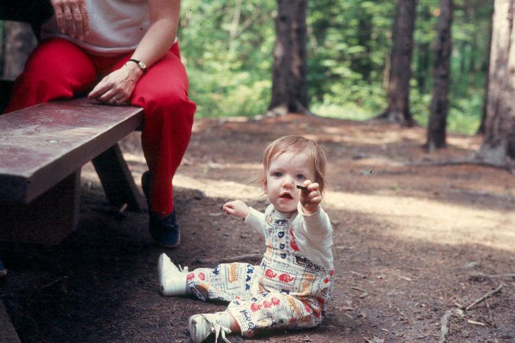 Marti Canipe as a baby sitting in a park