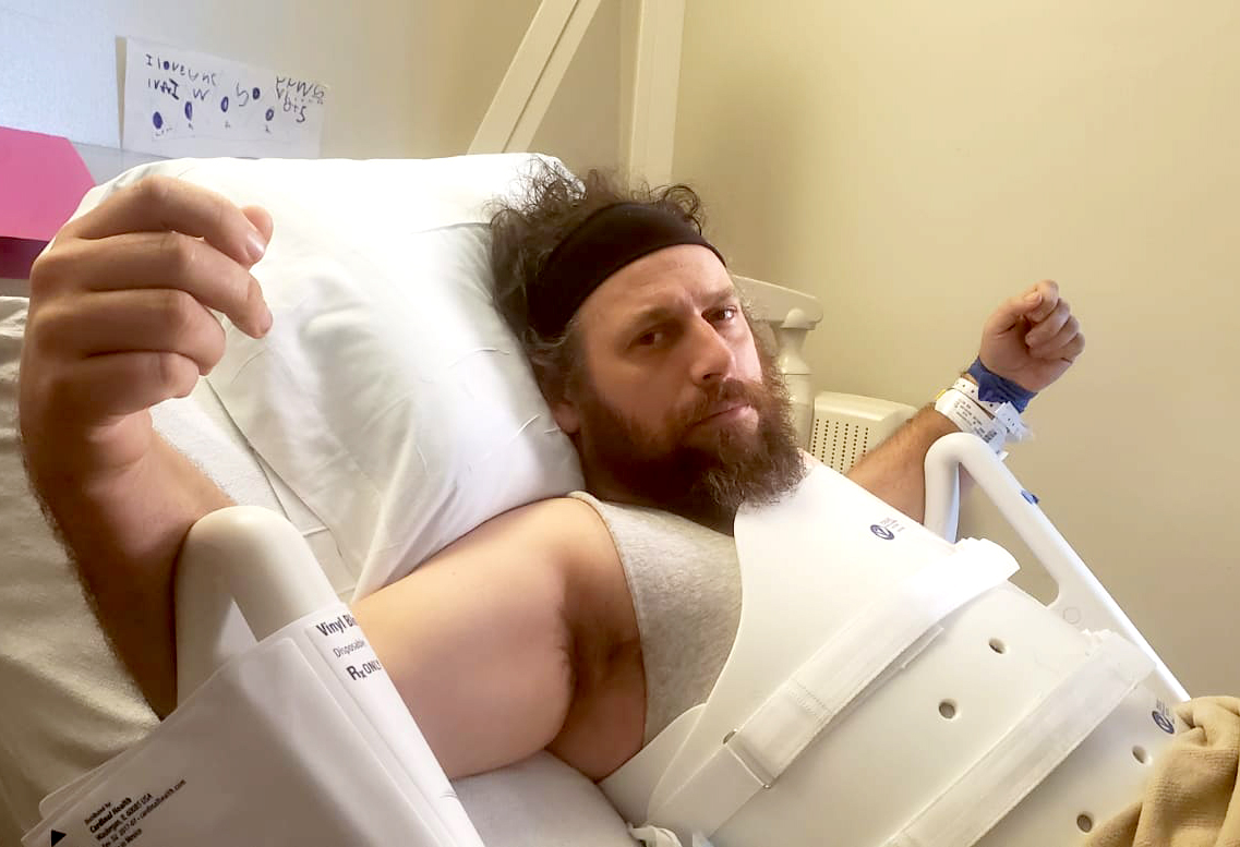 Ira Allen lays in hospital bed wearing back brace