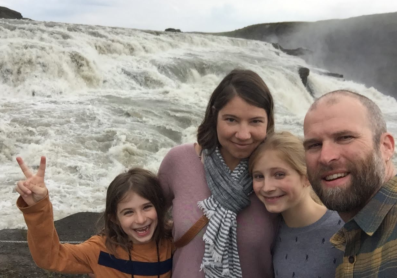 Christopher with his family infront of a waterfall.