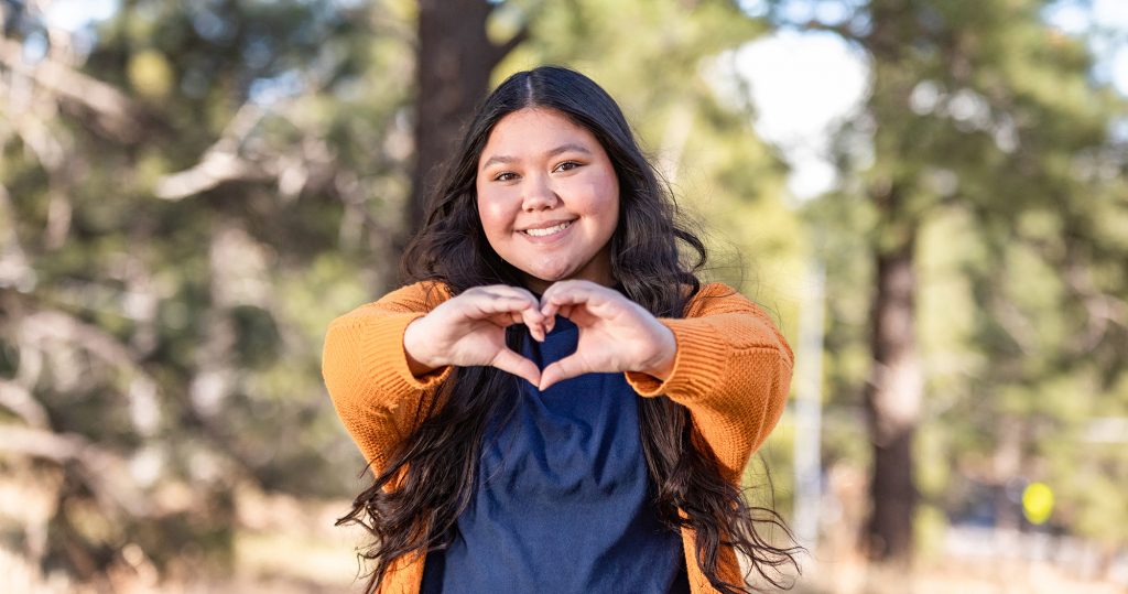 Student holds out heart hands