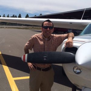 Matt Tantau stands by a plane behind a p