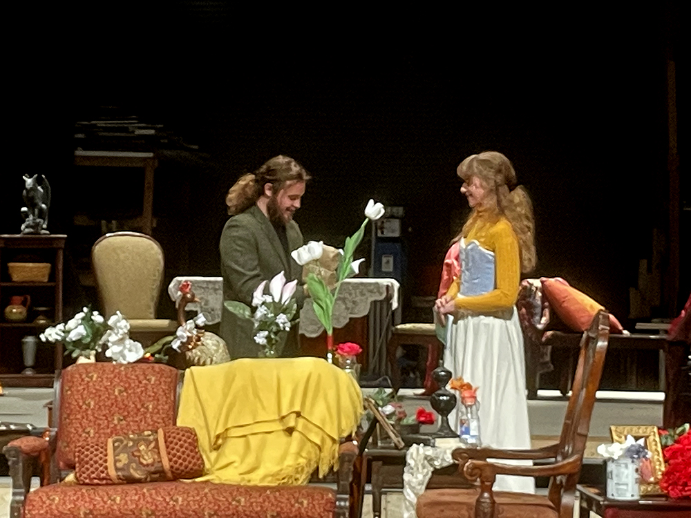 Two actors on stage in a living room set