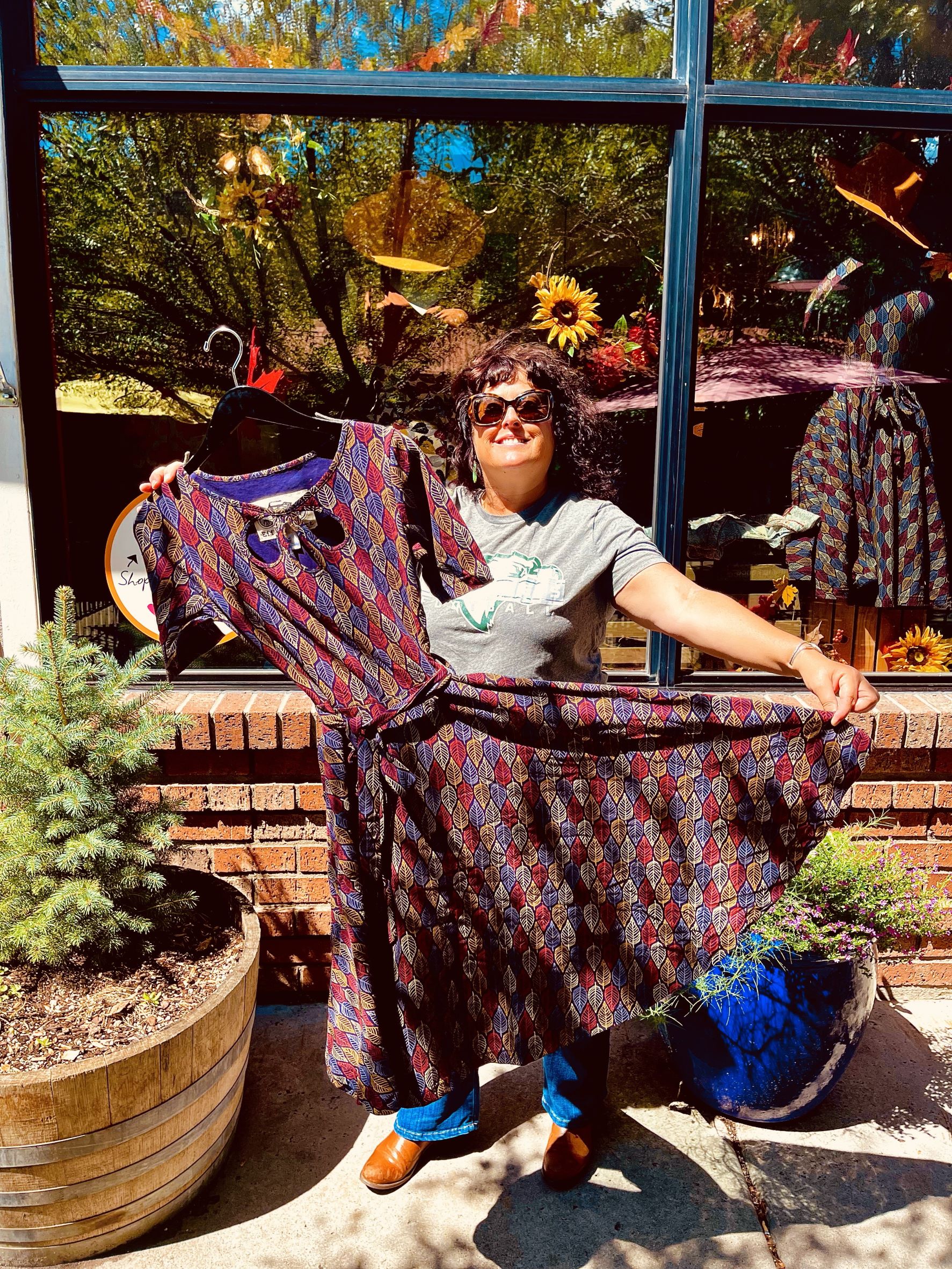 Miranda Sweet, owner of Rainbow’s End Boutique in downtown Flagstaff, holding a dress in front of her.