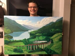 Brian Stone with a landscape painting of a train