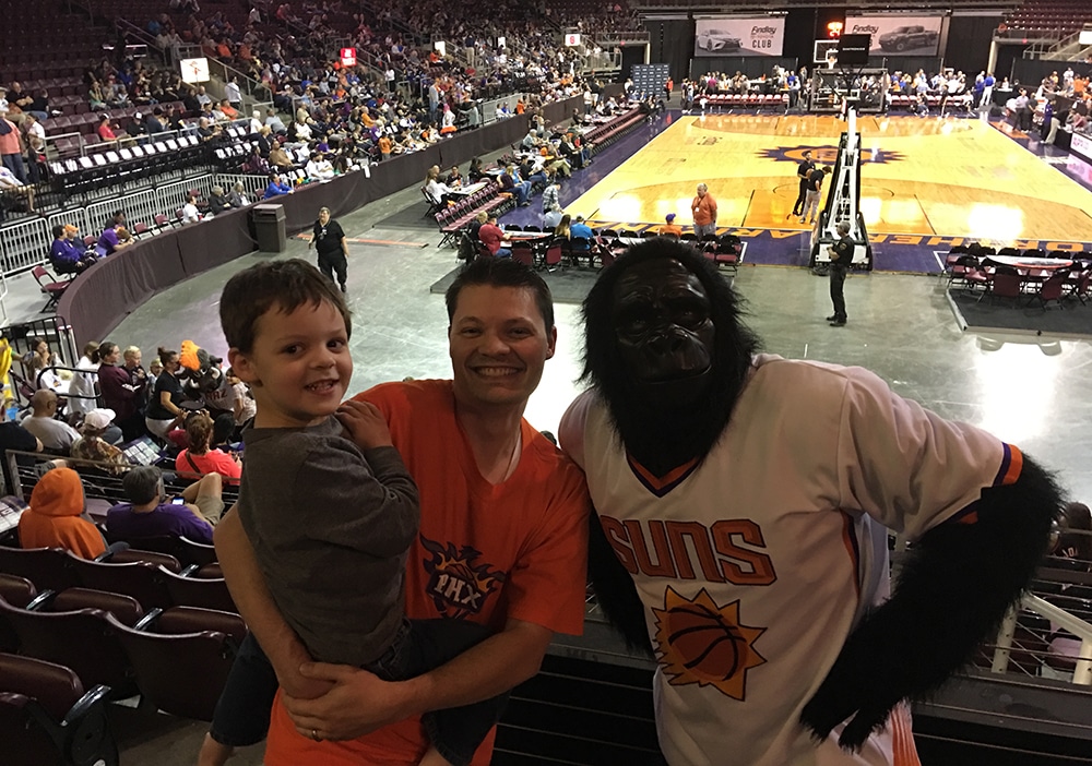 Brian Stone holding his son with the Phoenix Suns mascot