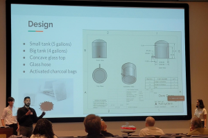 DewDrop team member explaing presentation slide on their design for water purification.