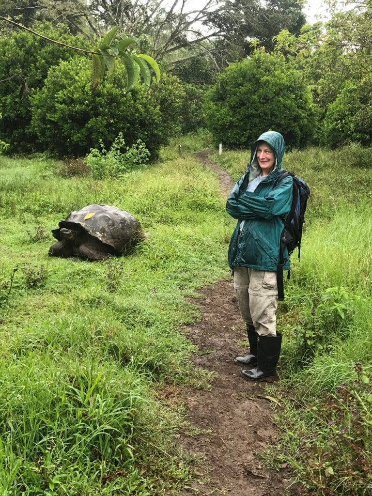 Erika Nowak in a raincoat in the field with a giant turtle