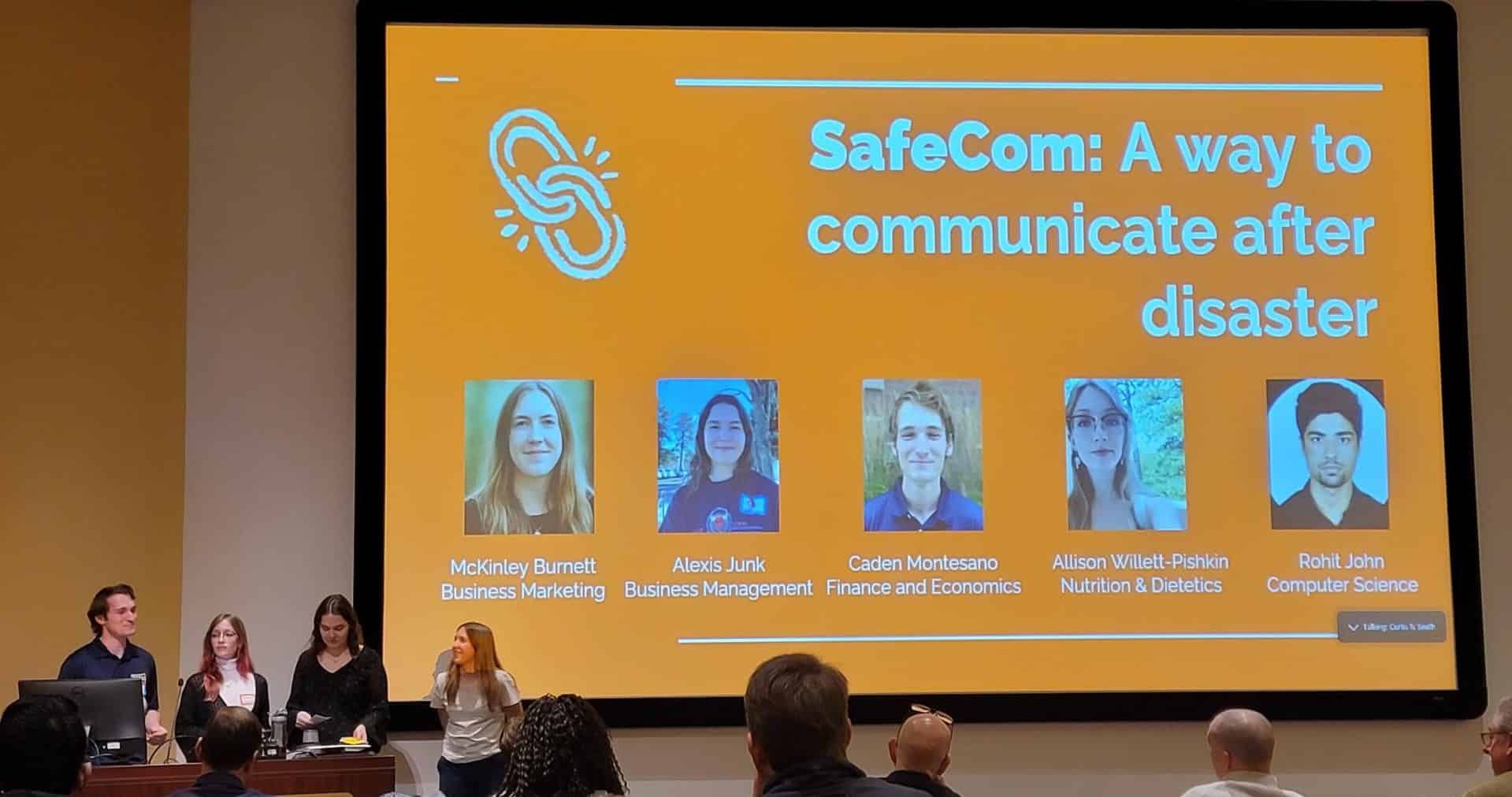 SafeCom beginning presentation. Four members in fron of presentation.