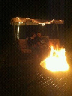 Cecilia Torres and her partner sitting in front of a fire