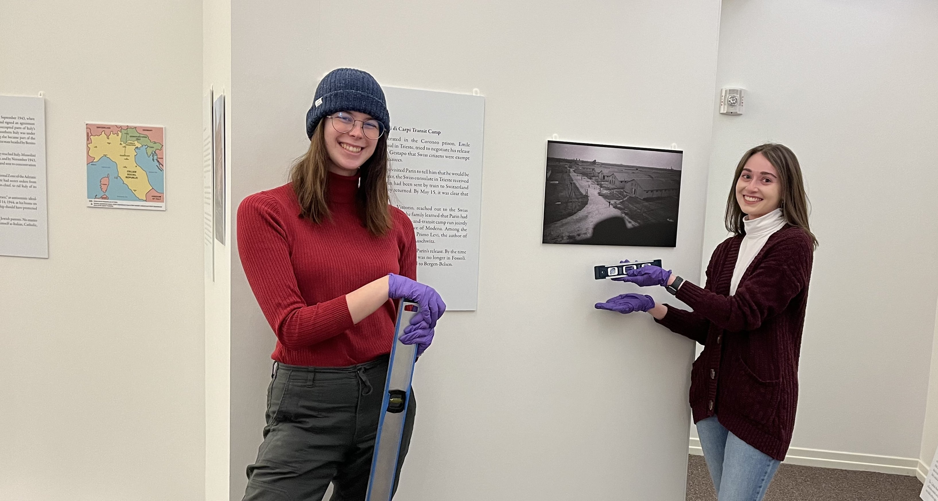 Alexis Nelson (left) and Elizabeth White (right) after installing the text panel and photograph about one of the Italian detention camps Gino Parin was sent to after his arrest by the Nazis. 