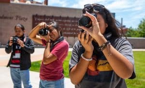 Three photography students in front of NAU Communication building