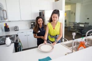 an OT student helps a patient learn kitchen skills.