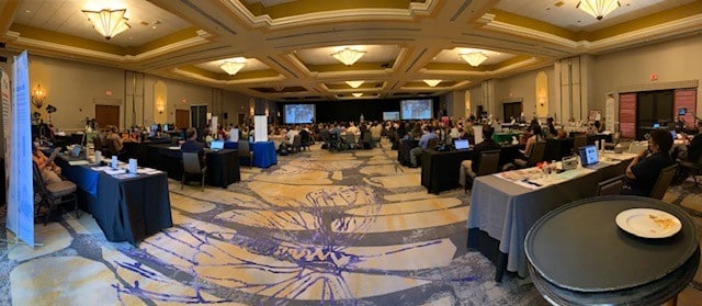 PIcture of conference room with people at tables