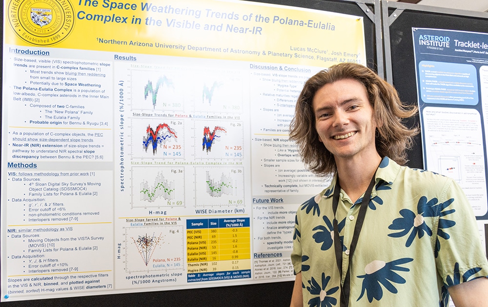 Lucas McClure in a Hawaiian shirt in front of a poster presentation