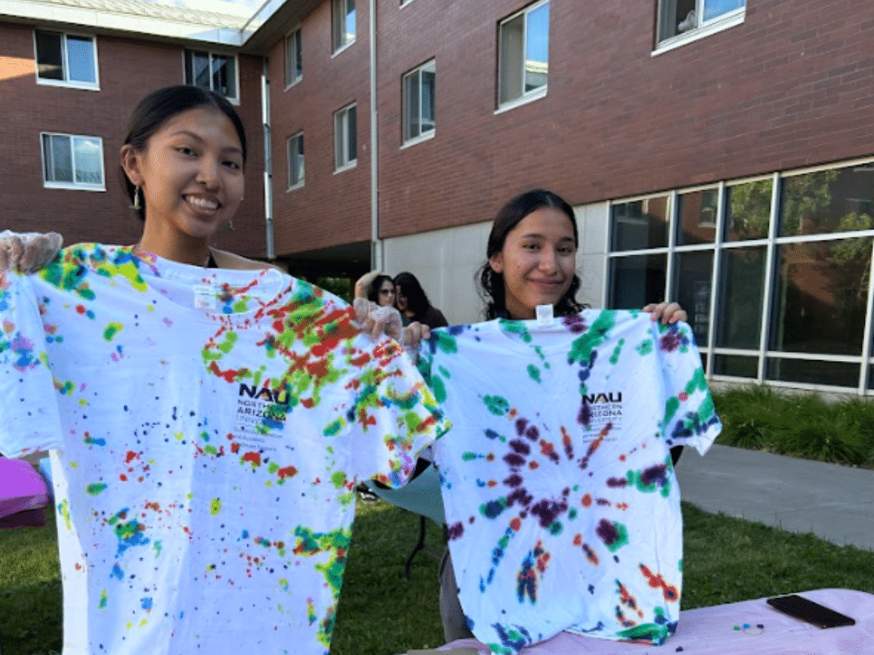 Students hold up their tie-dyed T-shirts.