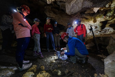 Students listen to Jut Wynne in a Belizean cave.