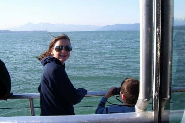 Teenage McKenzie standing on a cruise ship with the ocean and Alaska in the background.