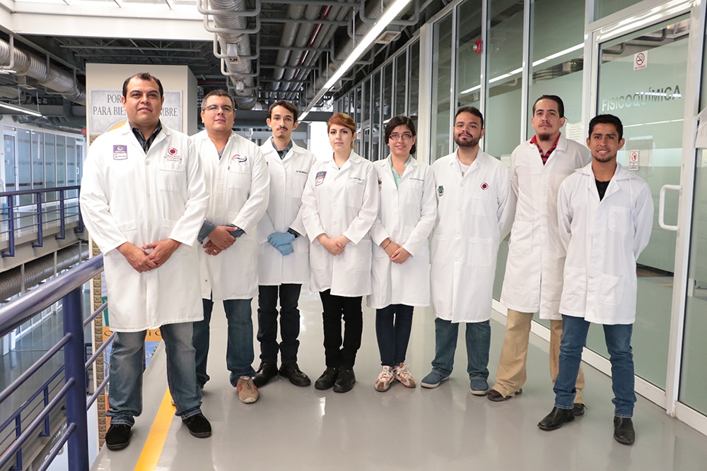 Victor Ramos Sanchez and seven scientists in white coats in the lab
