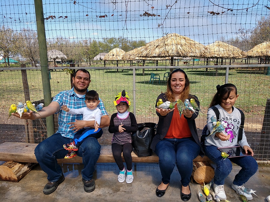 Victor Ramos Sanchez and his wife and three kids at the zoo holding birds