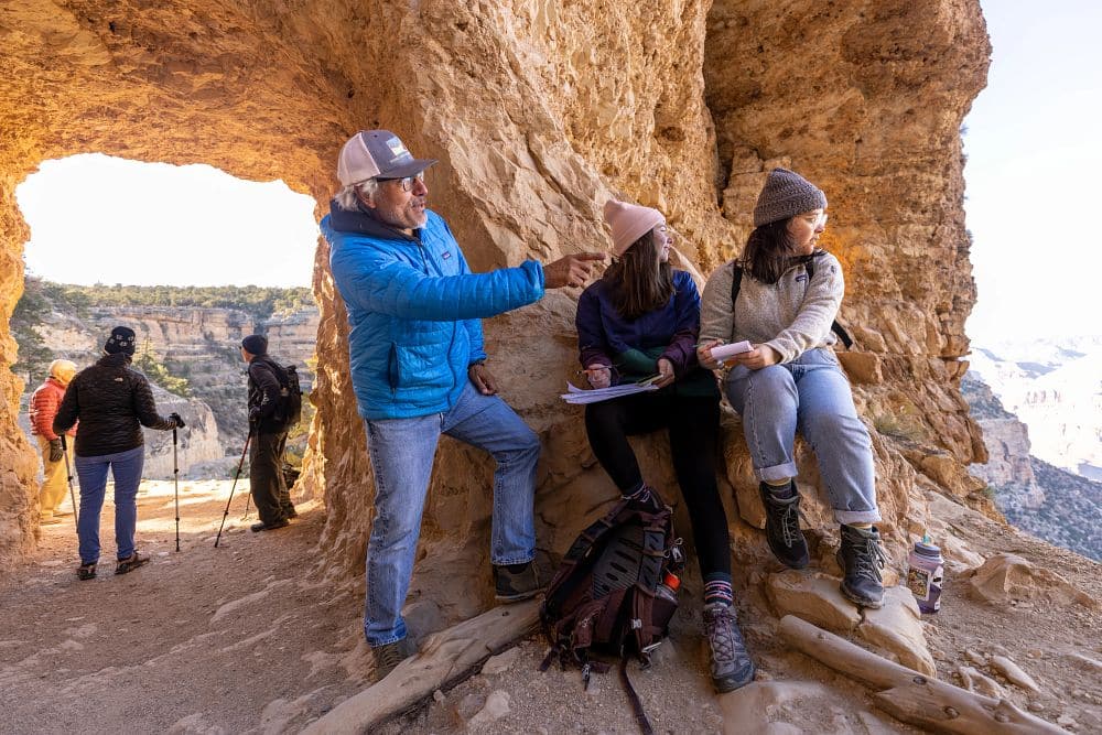 Honors College professor Ted Martinez talks to two students during a break in a hike in the Grand Canyon.