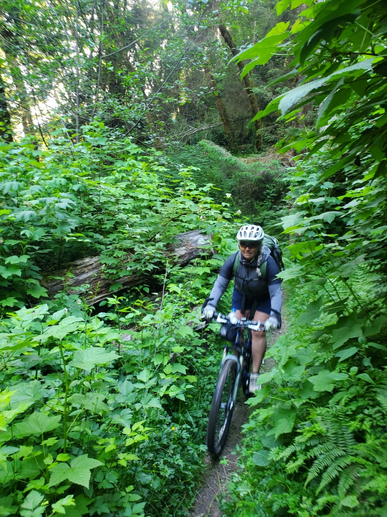 Emy Tice mountain biking through a jungle