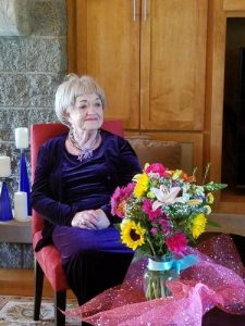 Doris Martin sitting in front of a bouquet of flowers