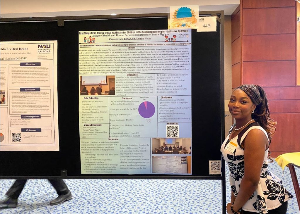 Cassie Bonah posing in front of a biomedical science poster she created