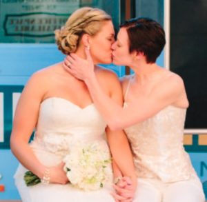 Meagan and Natalie Metz kissing in wedding attire