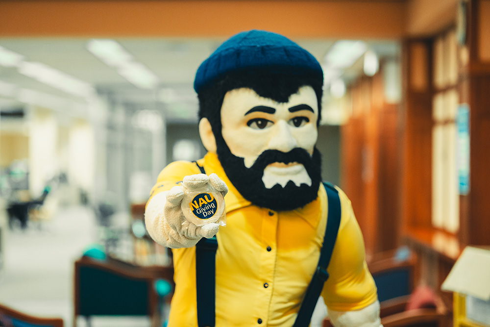 Louie the Lumberjack holds out an NAU Giving Day cookie.