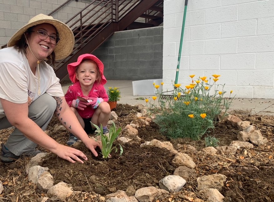 Janan and a young volunteer (a friend's daughter) installing a pollinator habitat in a local school garden.