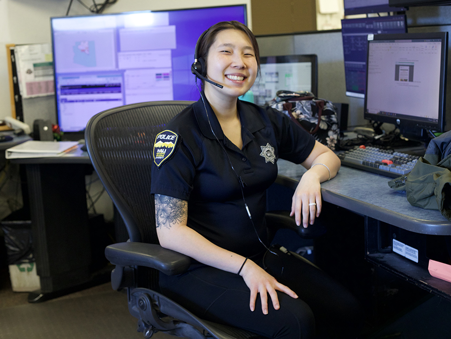 Dispatcher Jhordyn Bigelow in her uniform sitting at a desk.