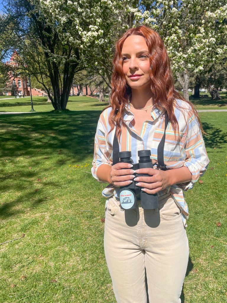 Victoria Wiley holding binoculars on a quad at NAU